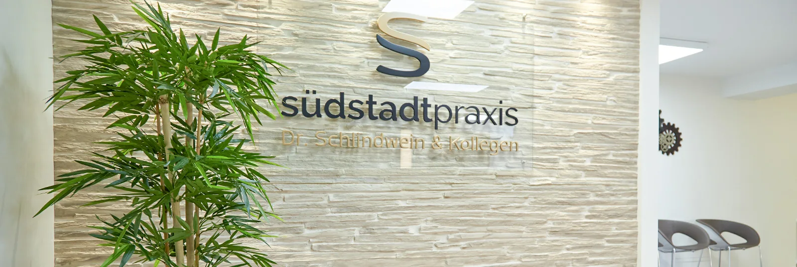Südstadtpraxis – praxis 05 Empfangsbereich der Südstadtpraxis mit Logo an der Wand